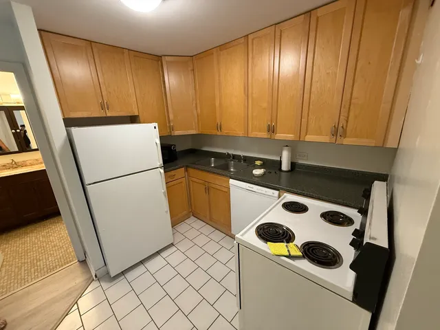 a kitchen with a refrigerator sink and cabinets