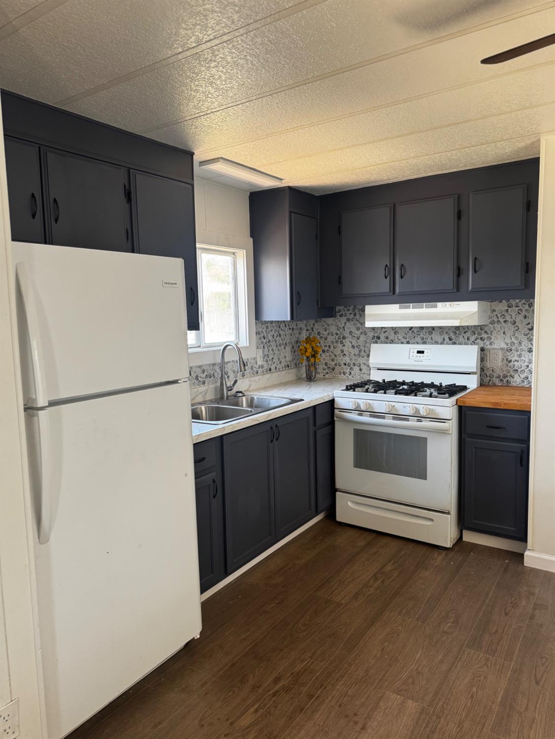 1200 South Carpenter Road, Unit 51 Modesto, CA 95351 - Photo 12 of 20 a kitchen with a refrigerator stove and white cabinets