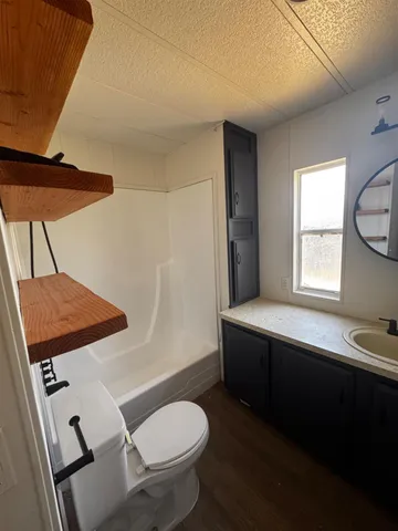 a bathroom with a sink mirror and toilet