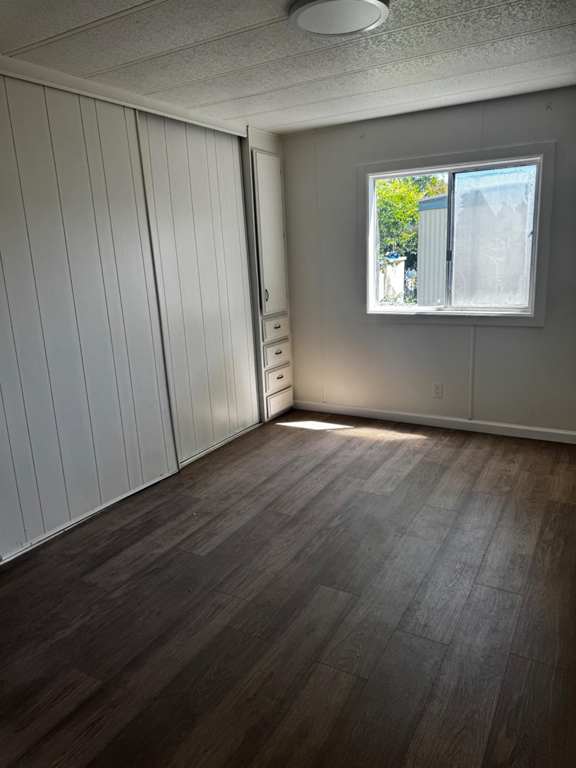 1200 South Carpenter Road, Unit 51 Modesto, CA 95351 - Photo 19 of 20 a view of an empty room with wooden floor and a window