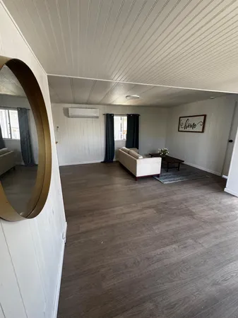 a living room with hard wood flooring and furniture