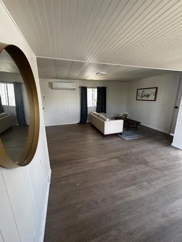 a living room with hard wood flooring and furniture