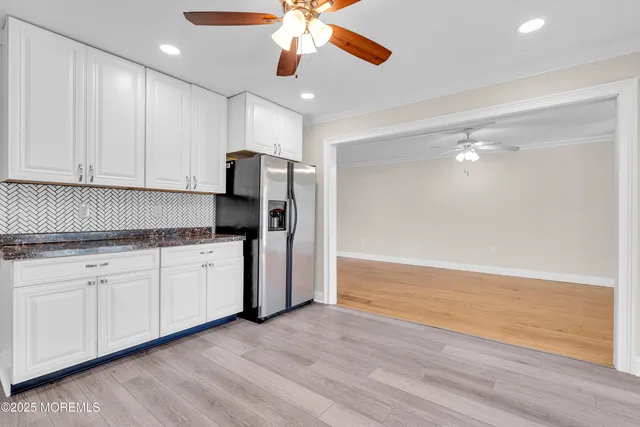 a kitchen with granite countertop a stove cabinets and wooden floor