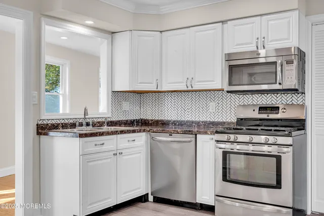 a view of a kitchen with a sink and wooden floor