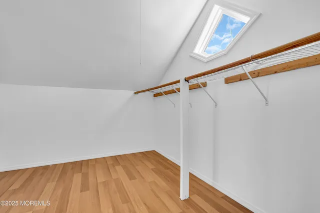 a view of empty room with wooden floor and ceiling fan