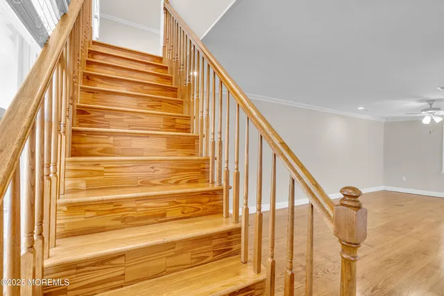 a view of empty room with wooden floor and ceiling fan
