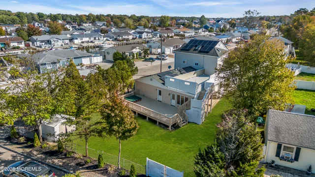an aerial view of ocean and residential houses with outdoor space