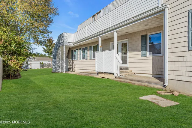 an aerial view of ocean and residential houses with outdoor space