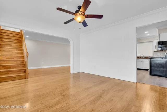 a view of an empty room with window and a kitchen