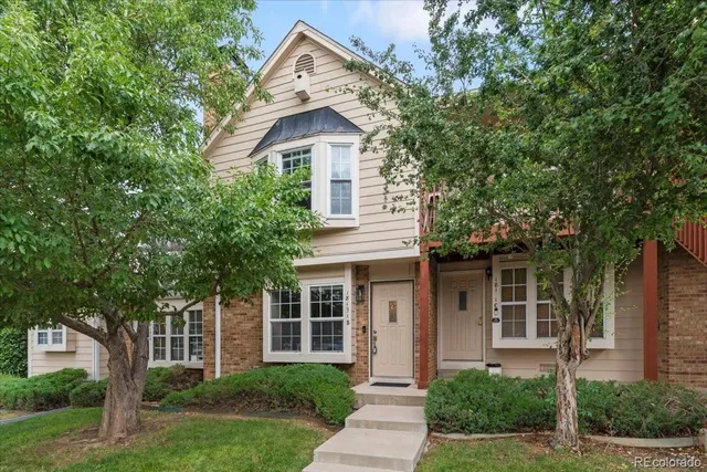 a front view of a house with a yard and potted plants