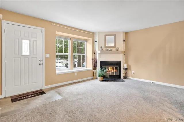a view of an empty room with a window and fireplace