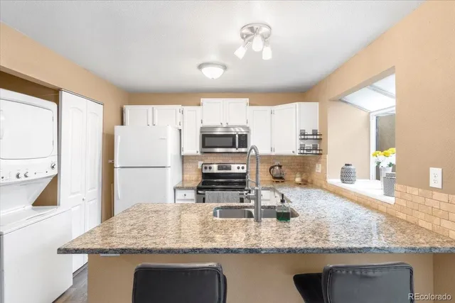 a kitchen with kitchen island granite countertop a sink stove and refrigerator