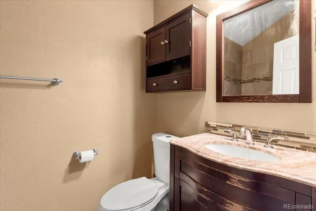 a bathroom with a sink a toilet and mirror