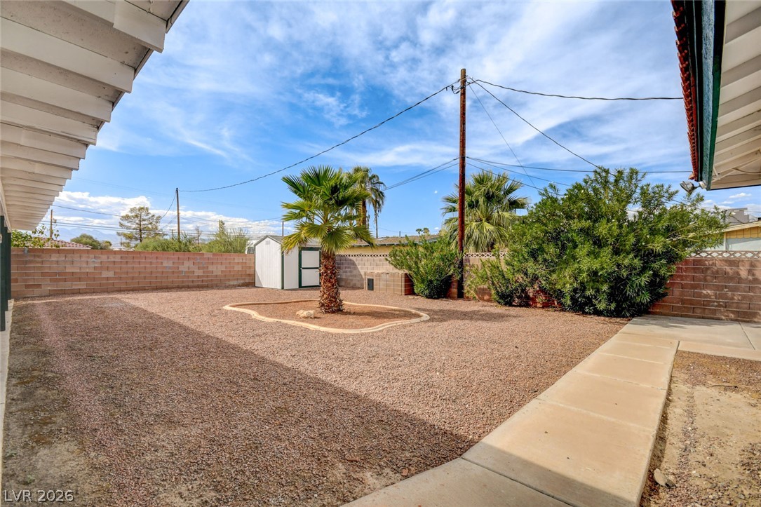 1401 Sharon Road Las Vegas, NV 89106 - Photo 64 of 73 A spacious gravel backyard features a security block wall, storage shed, and mature palm tree.