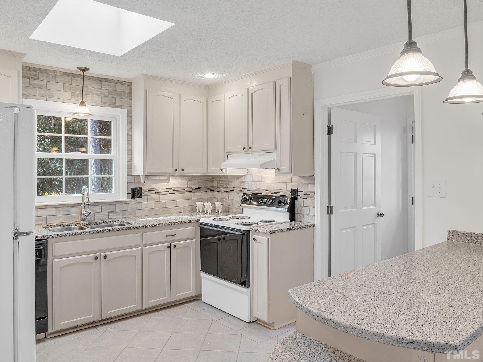 1509 Windbur Place Raleigh, NC 27609 - Photo 13 of 39 a kitchen with a sink stove and cabinets