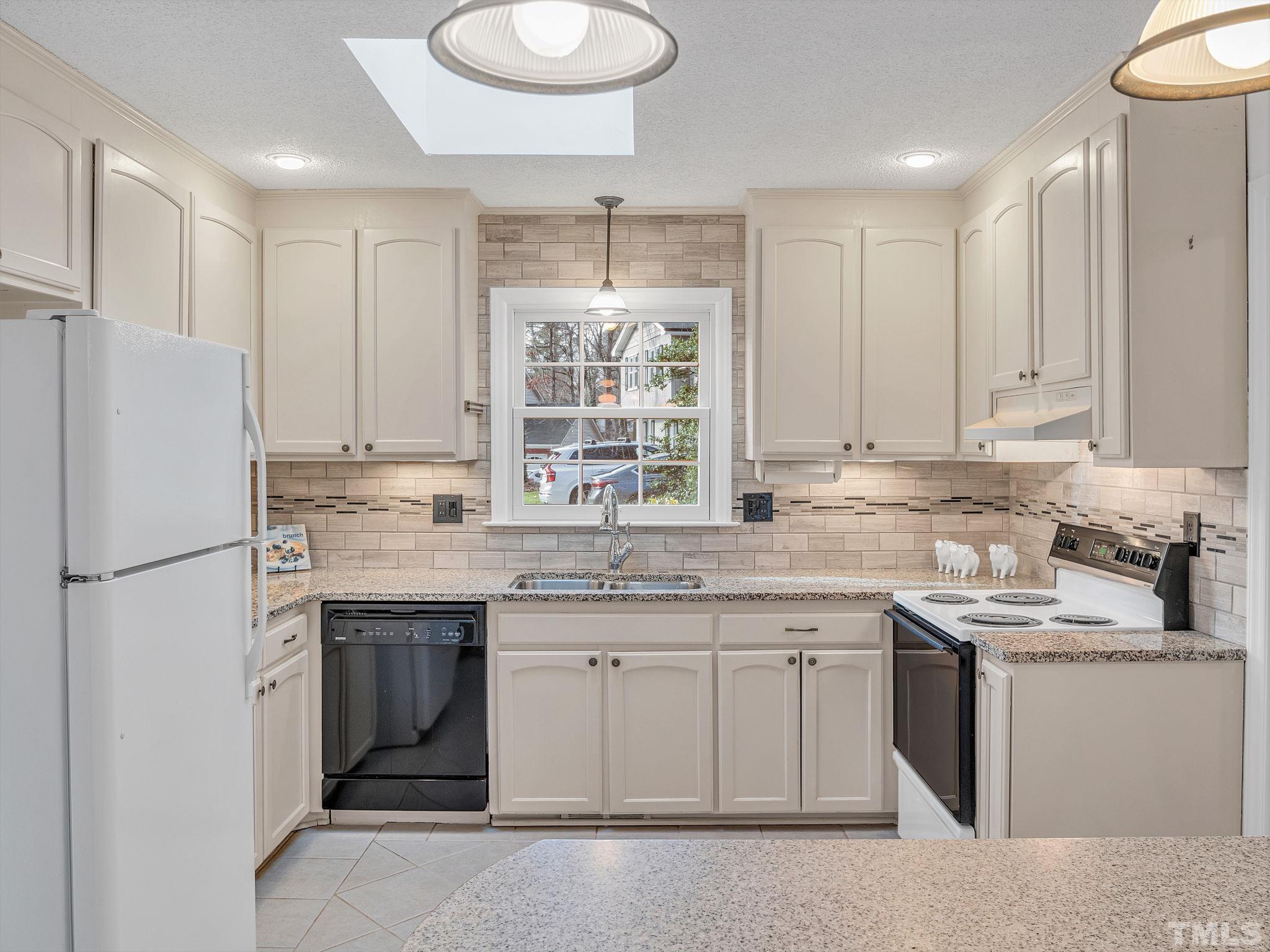 1509 Windbur Place Raleigh, NC 27609 - Photo 14 of 39 a kitchen with a sink stove and white cabinets