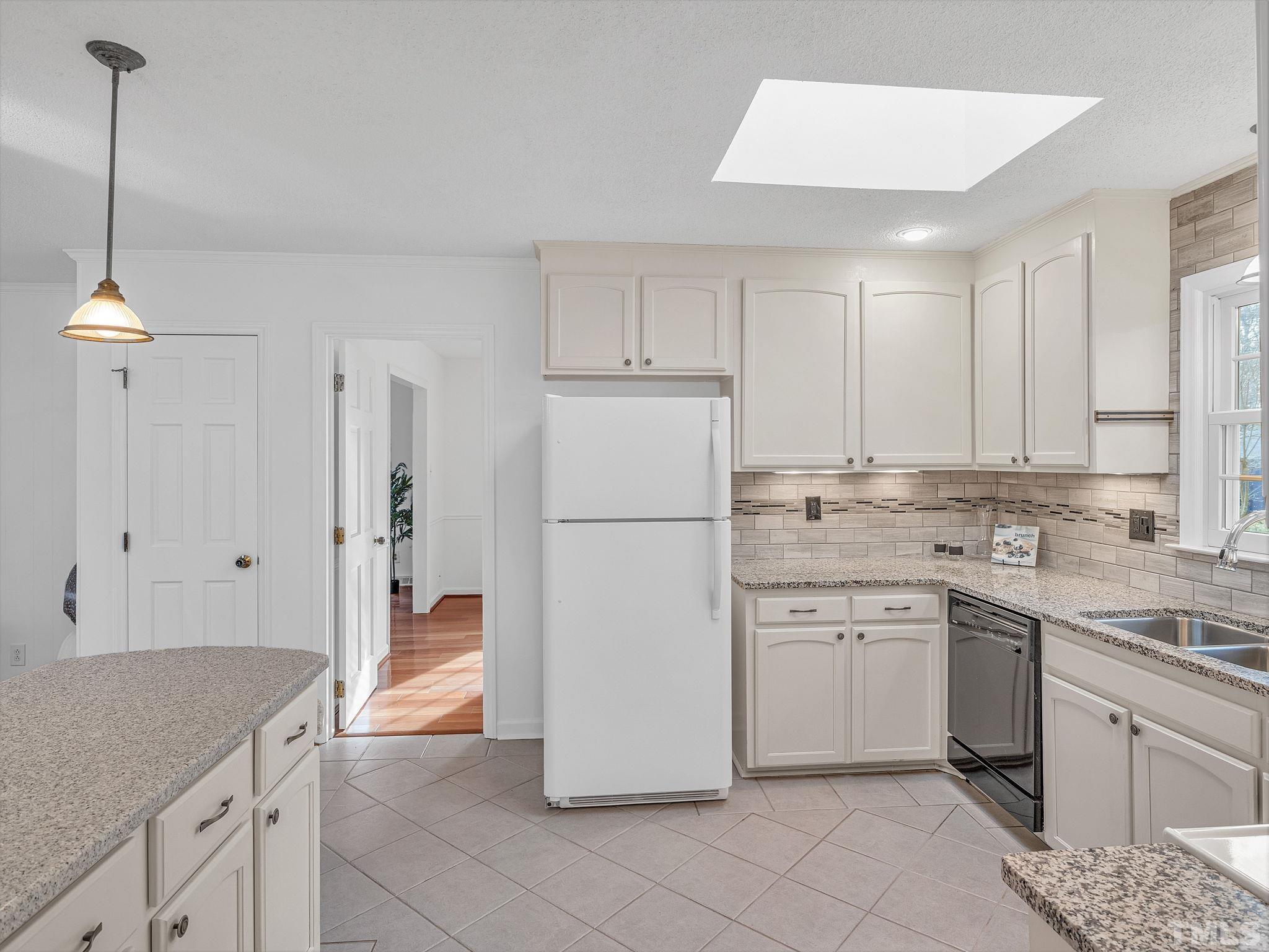1509 Windbur Place Raleigh, NC 27609 - Photo 15 of 39 a kitchen with a sink a refrigerator and cabinets