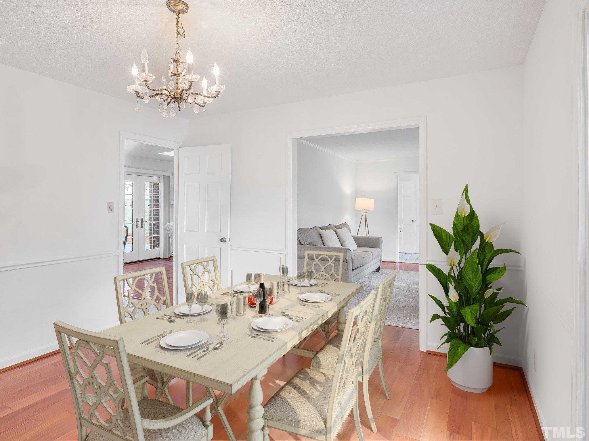 1509 Windbur Place Raleigh, NC 27609 - Photo 18 of 39 a dining room with furniture potted plants and wooden floor