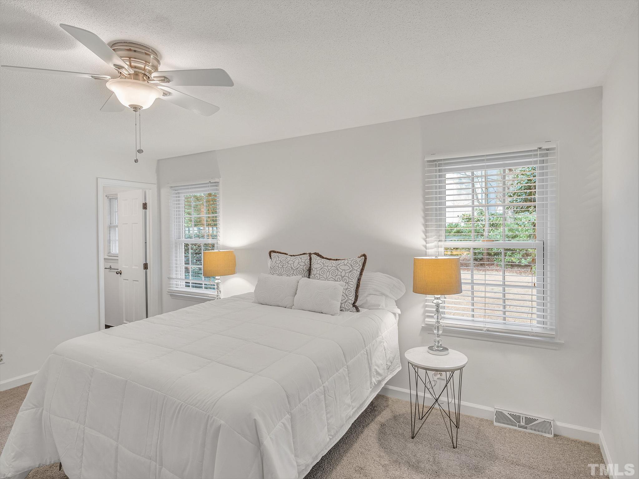 1509 Windbur Place Raleigh, NC 27609 - Photo 23 of 39 a bedroom with a bed and a chandelier