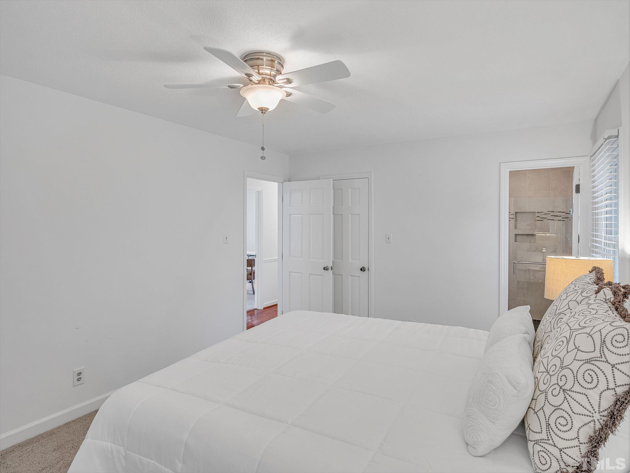 1509 Windbur Place Raleigh, NC 27609 - Photo 24 of 39 a bedroom with a bed and a chandelier