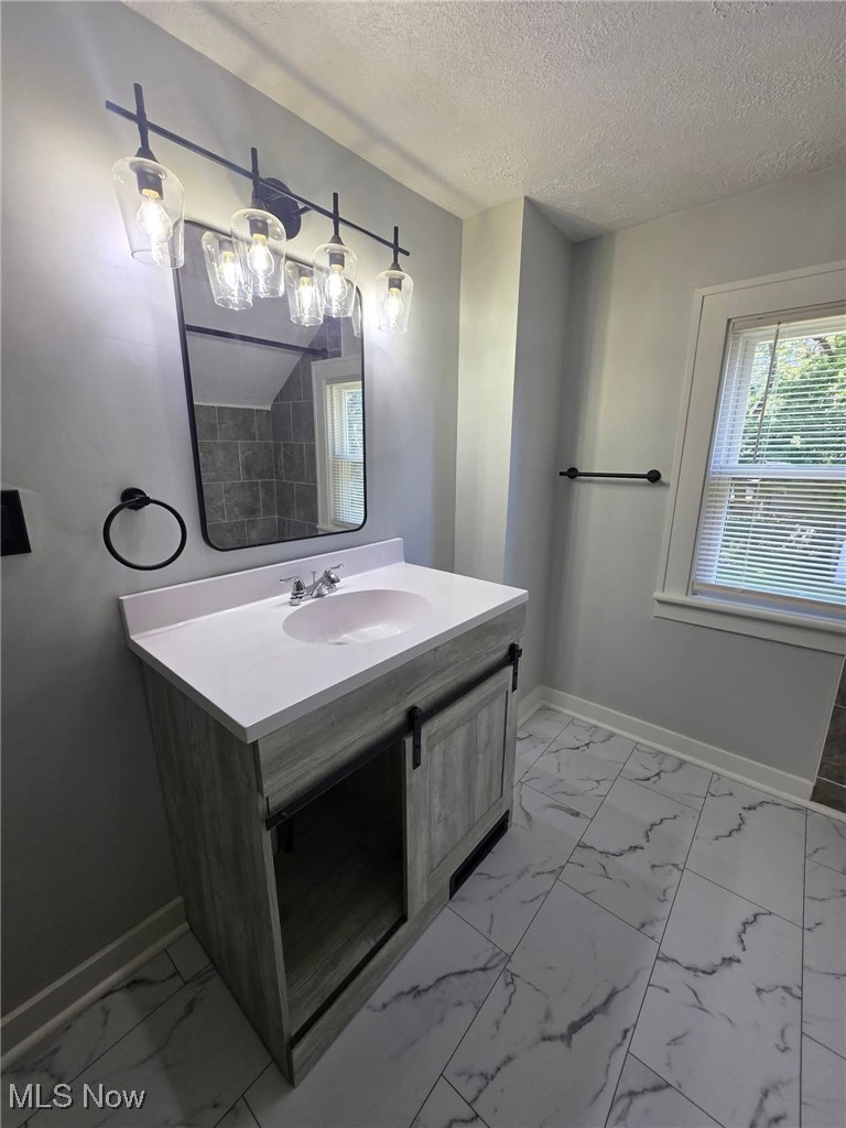 899 Davis Street Akron, OH 44310 - Photo 11 of 20 Bathroom featuring vanity, light marble finish flooring, and a textured ceiling