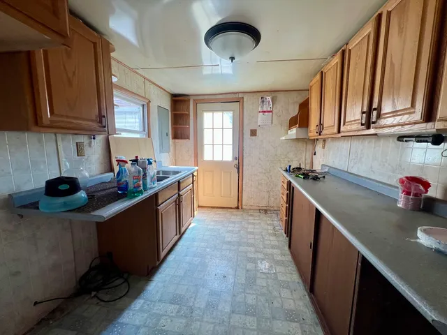 a kitchen with stainless steel appliances granite countertop a sink counter space cabinets and a window