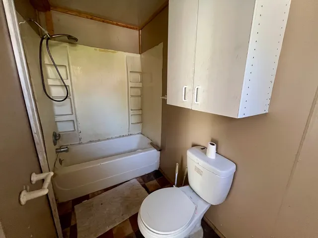 a bathroom with a toilet and a shower