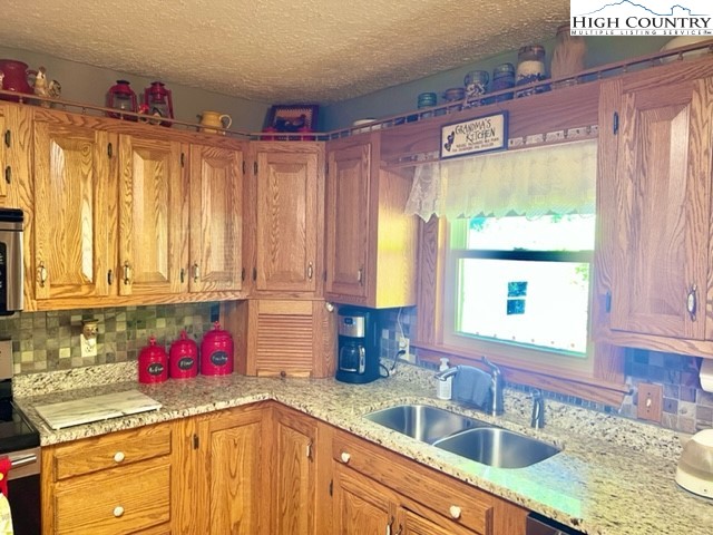 191 Welch Road Lansing, NC 28643 - Photo 15 of 41 a kitchen with granite countertop a sink window and cabinets