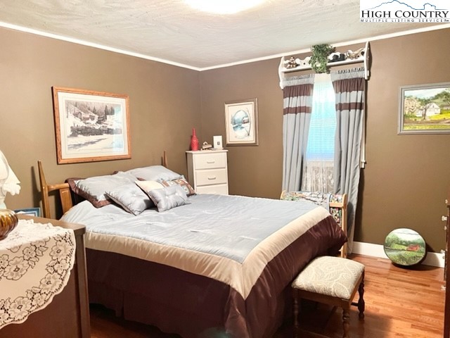 191 Welch Road Lansing, NC 28643 - Photo 19 of 41 a bedroom with bed and wooden floor