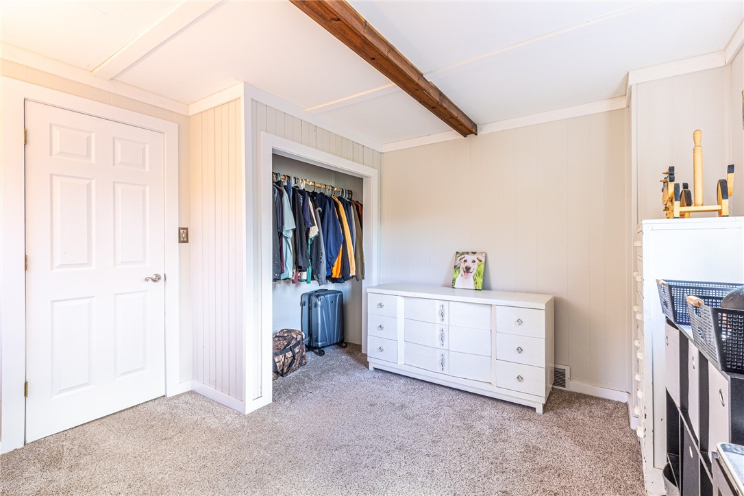 6432 Lakeside Road Ontario, NY 14519 - Photo 26 of 35 A rustic wooden ceiling beam accents this bedroom featuring soft carpeting and a closet.