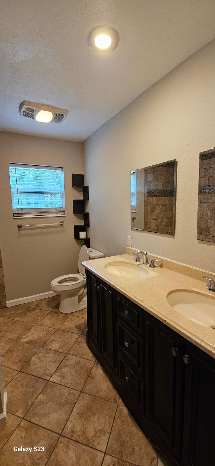 4102 California Avenue Dickinson, TX 77539 - Photo 13 of 19 a bathroom with a double vanity sink a toilet and mirror