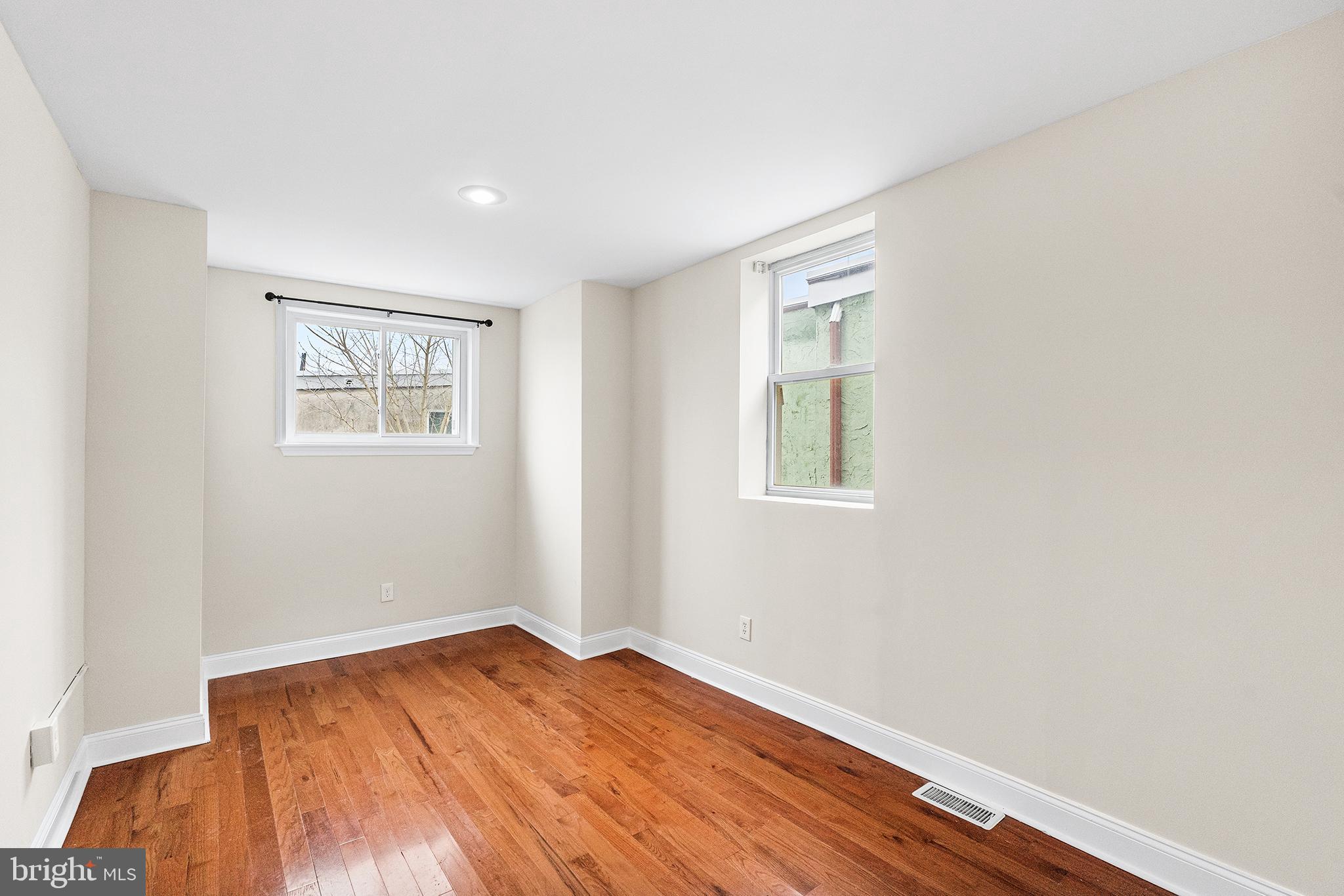 1538 Tasker Street Philadelphia, PA 19145 - Photo 14 of 23 an empty room with wooden floor and windows