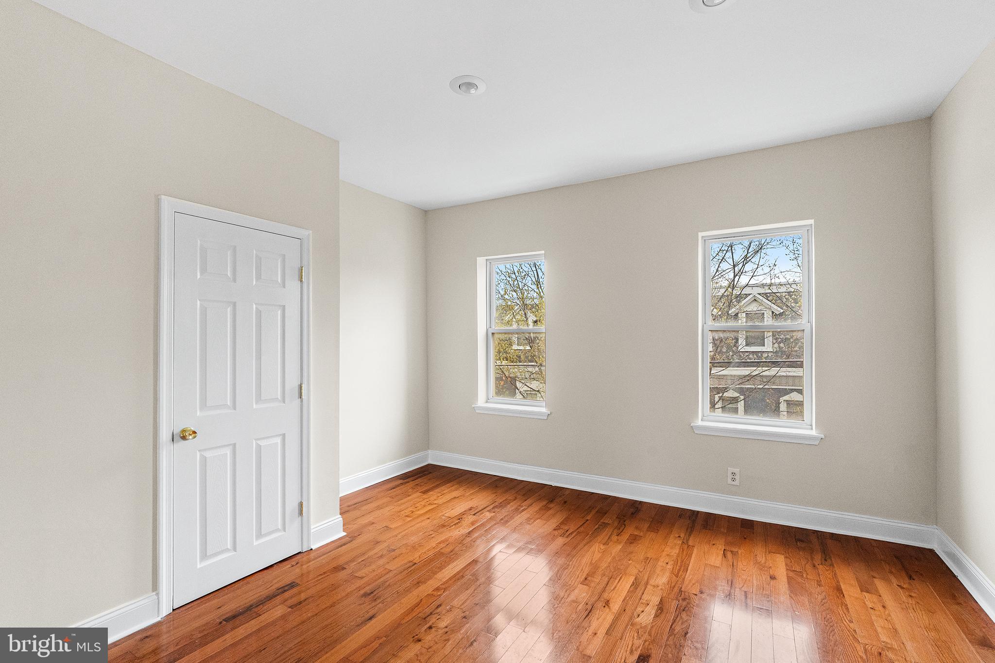 1538 Tasker Street Philadelphia, PA 19145 - Photo 18 of 23 an empty room with wooden floor and windows