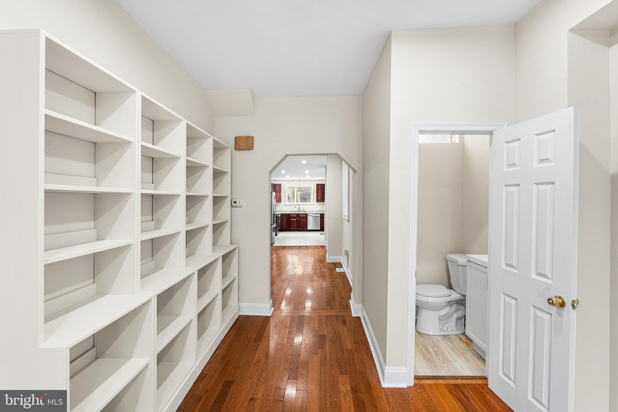 1538 Tasker Street Philadelphia, PA 19145 - Photo 5 of 23 a view of a hallway to a livingroom with wooden floor and furniture