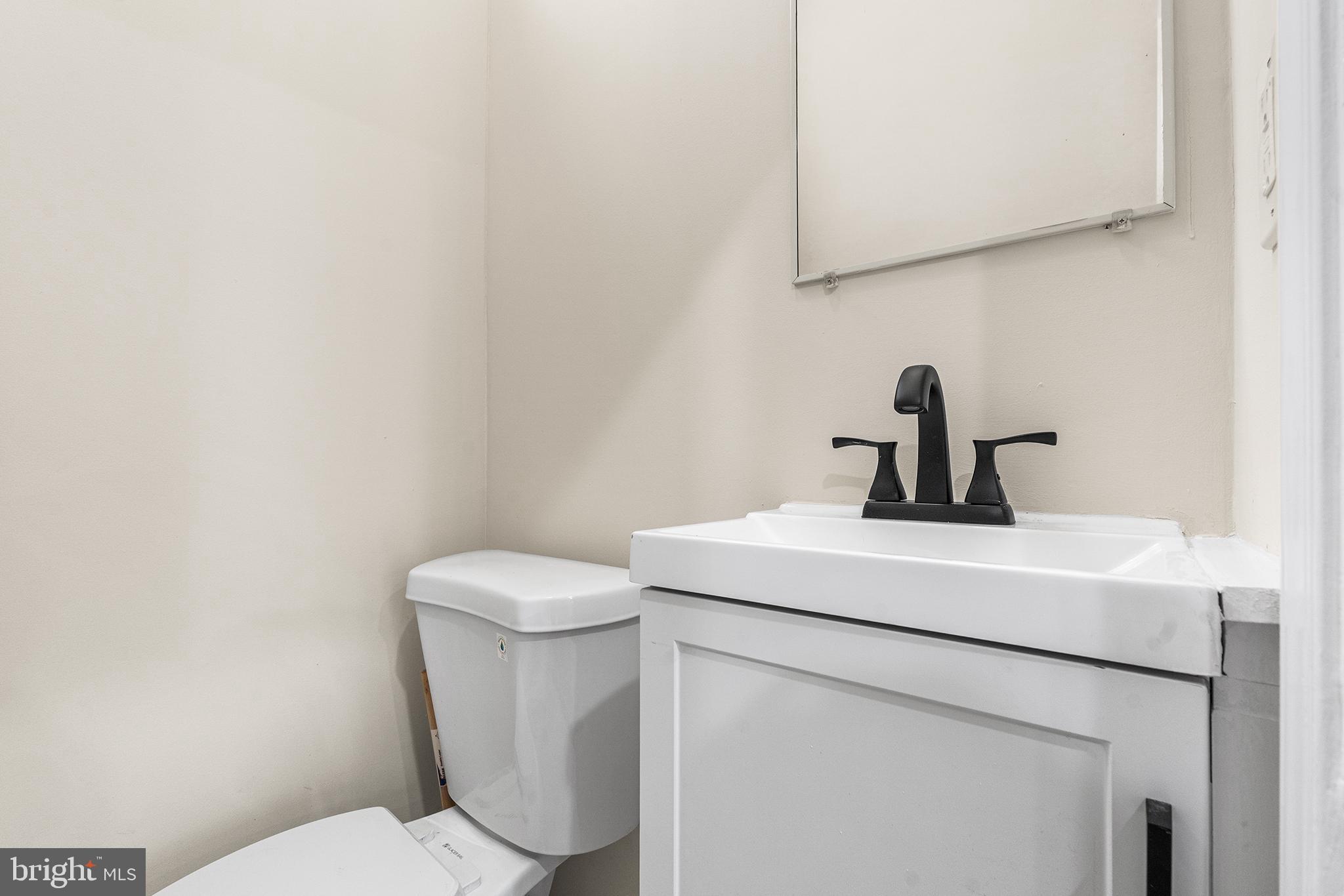 1538 Tasker Street Philadelphia, PA 19145 - Photo 6 of 23 a bathroom with a toilet sink and mirror