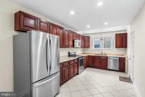 a kitchen with stainless steel appliances granite countertop a refrigerator sink and stove