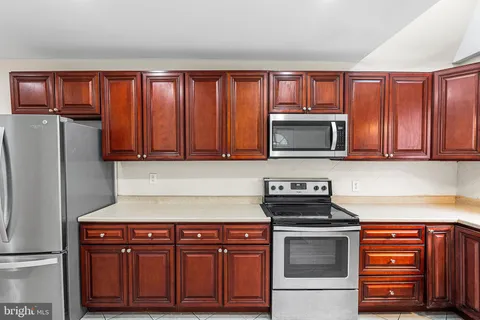 a kitchen with granite countertop stainless steel appliances and wooden cabinets