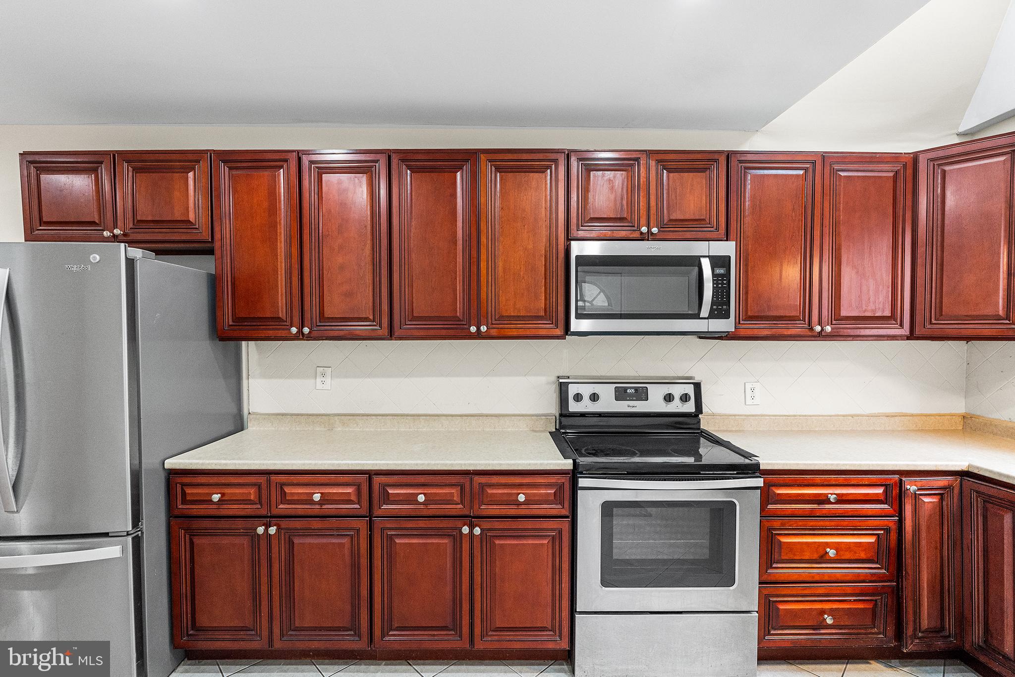 1538 Tasker Street Philadelphia, PA 19145 - Photo 10 of 23 a kitchen with granite countertop stainless steel appliances and wooden cabinets