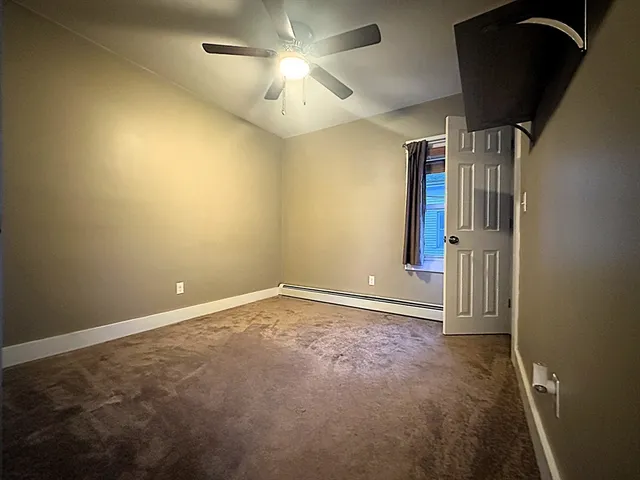 en empty room with windows and ceiling fan