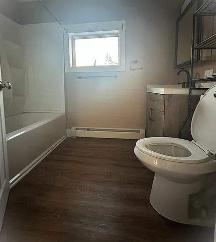 a white toilet sitting next to a bathroom sink and a window