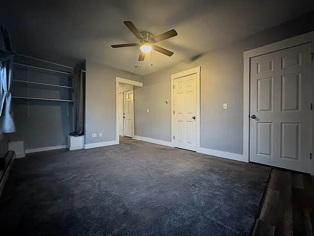 an empty room with closet and windows