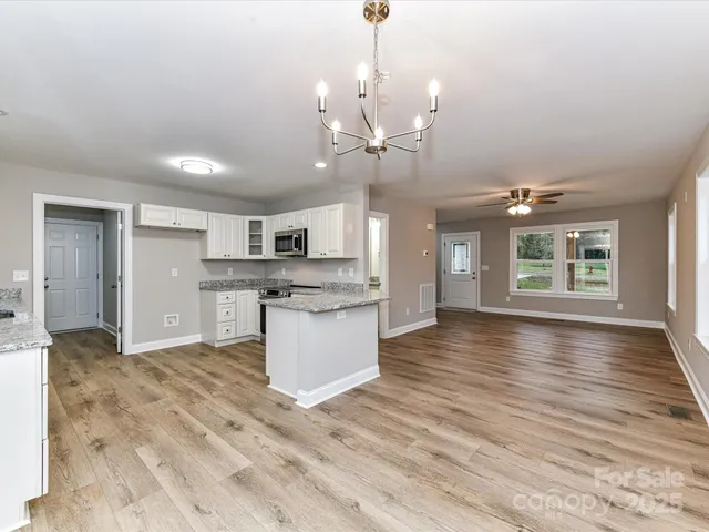a view of a kitchen with a sink and wooden floor