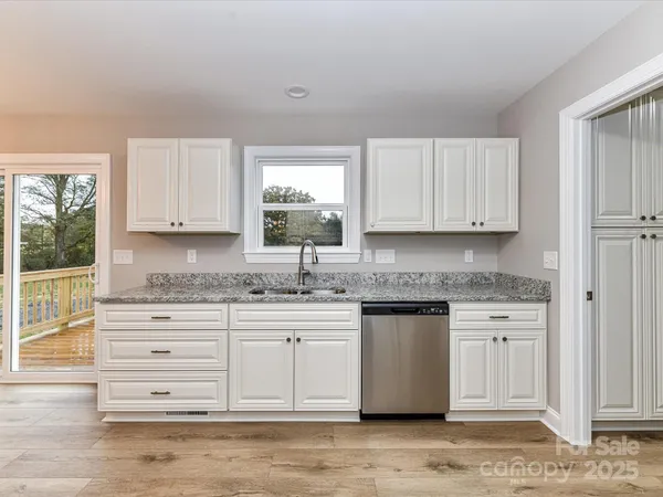 a kitchen with granite countertop a sink cabinets and window