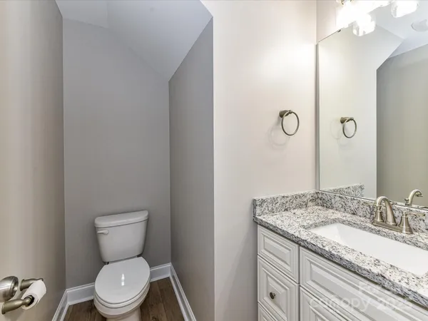 a bathroom with a granite countertop toilet sink and mirror