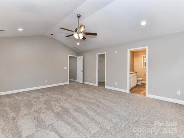 a bathroom with a granite countertop sink a large mirror a toilet and a bathtub
