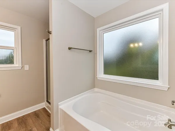 a spacious bathroom with a granite countertop tub a double vanity sink and mirror