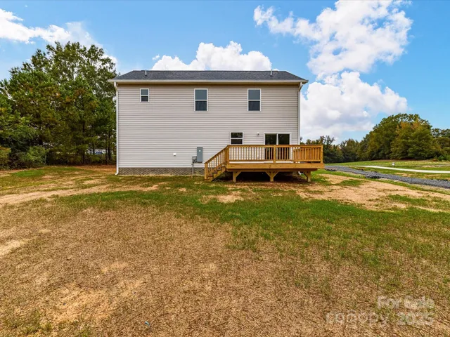 a view of a house with a big yard and a large tree