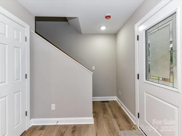 a view of a hallway with wooden floor and staircase