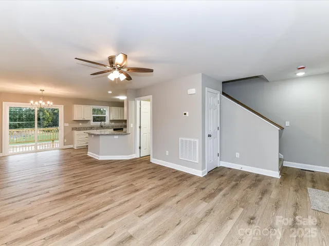 a view of a kitchen with wooden floor and a ceiling fan