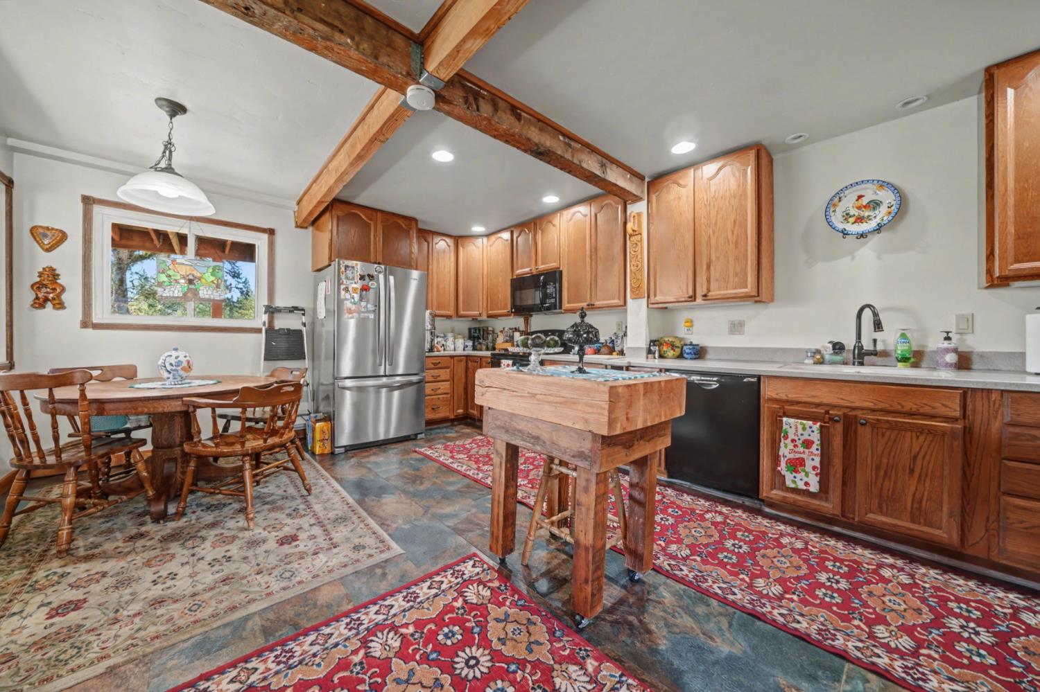 3341 Newtown Road Placerville, CA 95667 - Photo 14 of 49 a open kitchen with stainless steel appliances granite countertop a stove top oven a refrigerator a sink and dishwasher with a dining table